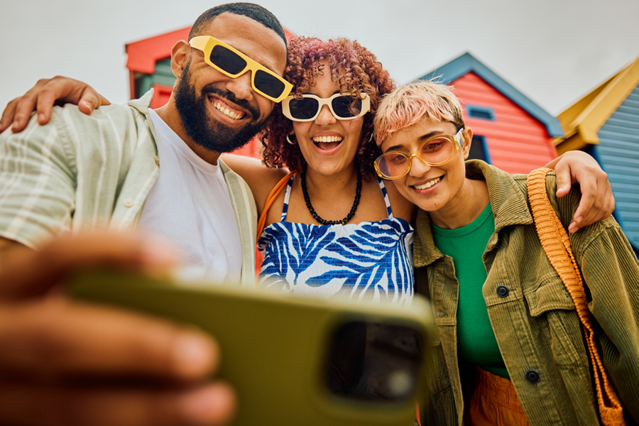 Friends taking a selfie and smiling with sunglasses on.