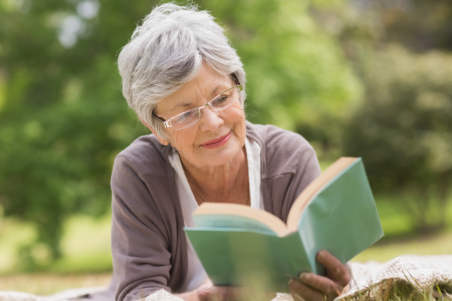 Older adult reading in the sun.